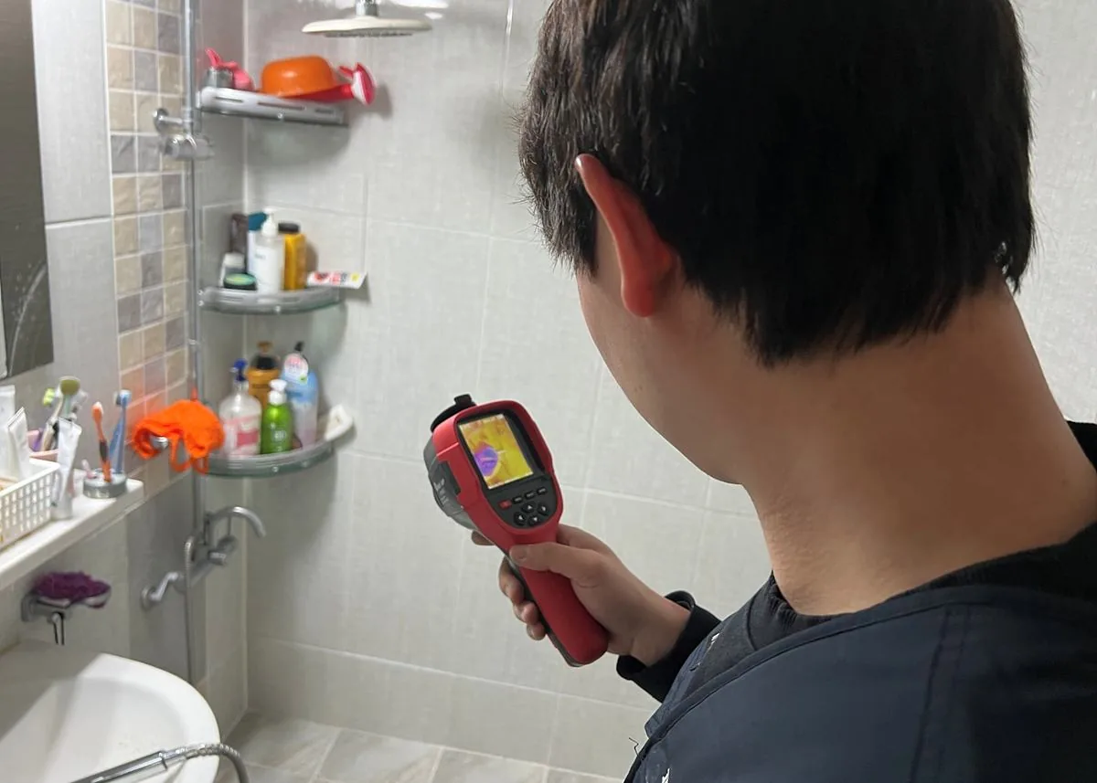 화장실 바닥을 열화상카메라로 점검하는 모습